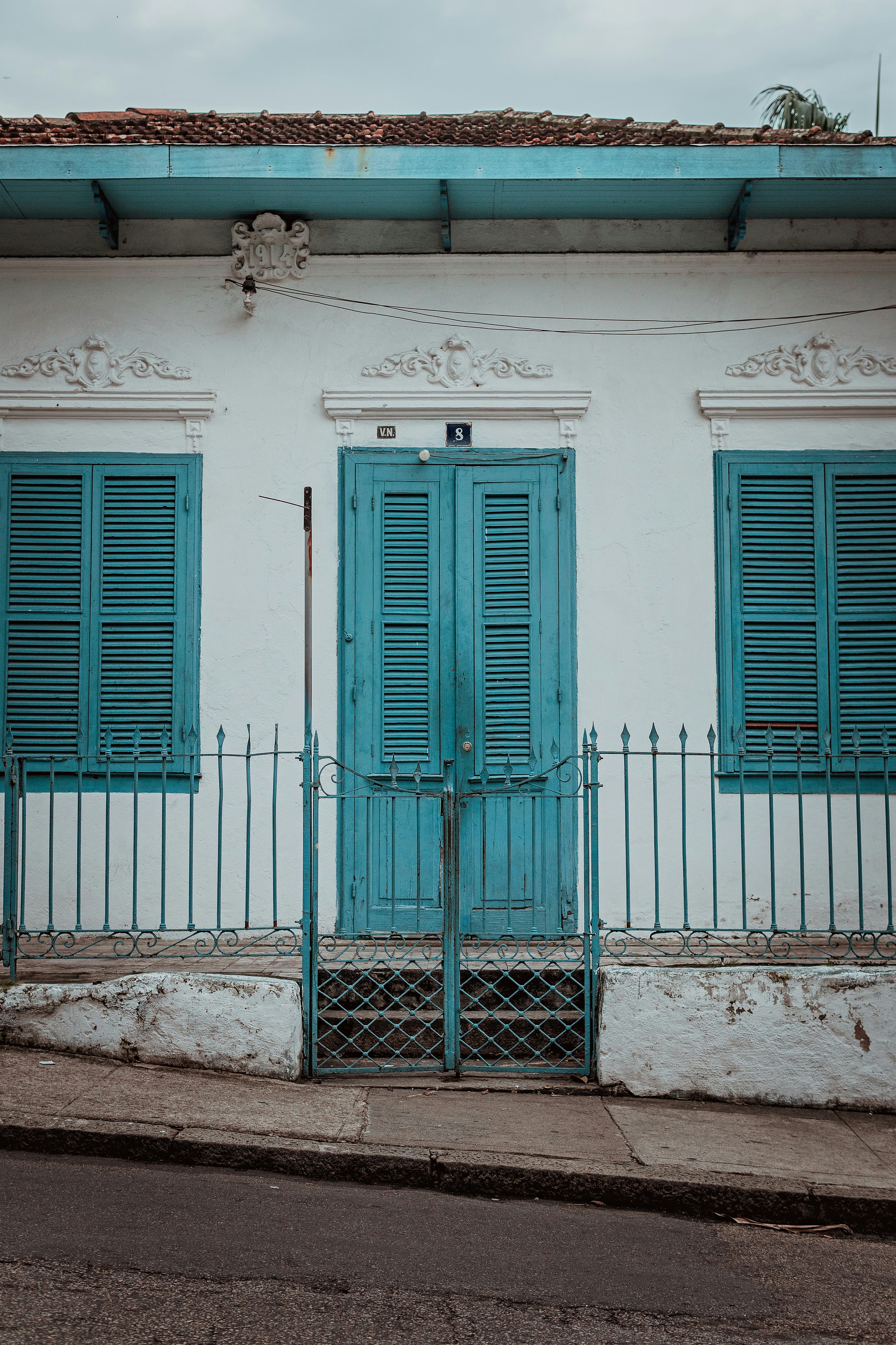 white and teal concrete house at daytime